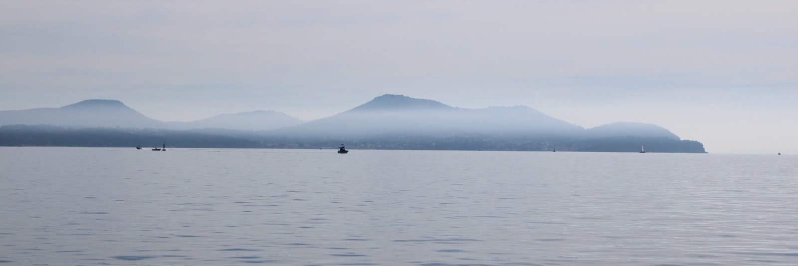 Des collines dans la brume au-dessus de l'eau